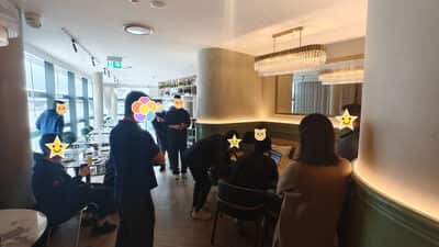 另一个角度的同一片场地，靠窗一排陆续坐下