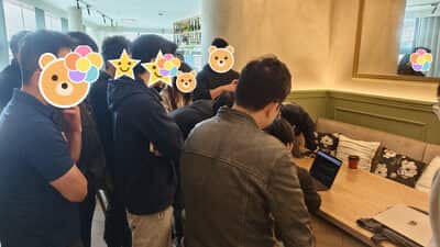 开场前站着聊的一群人，旁边桌上摊着两台电脑